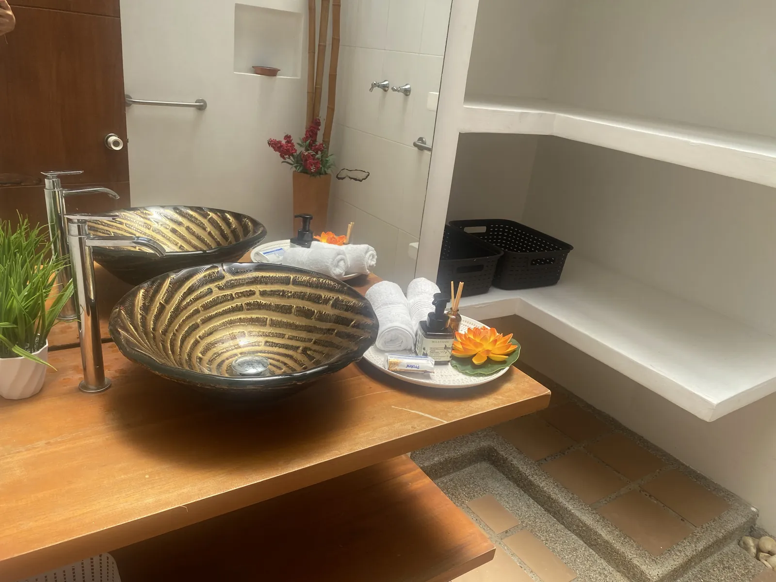 Baño con lavamanos dorado y ducha