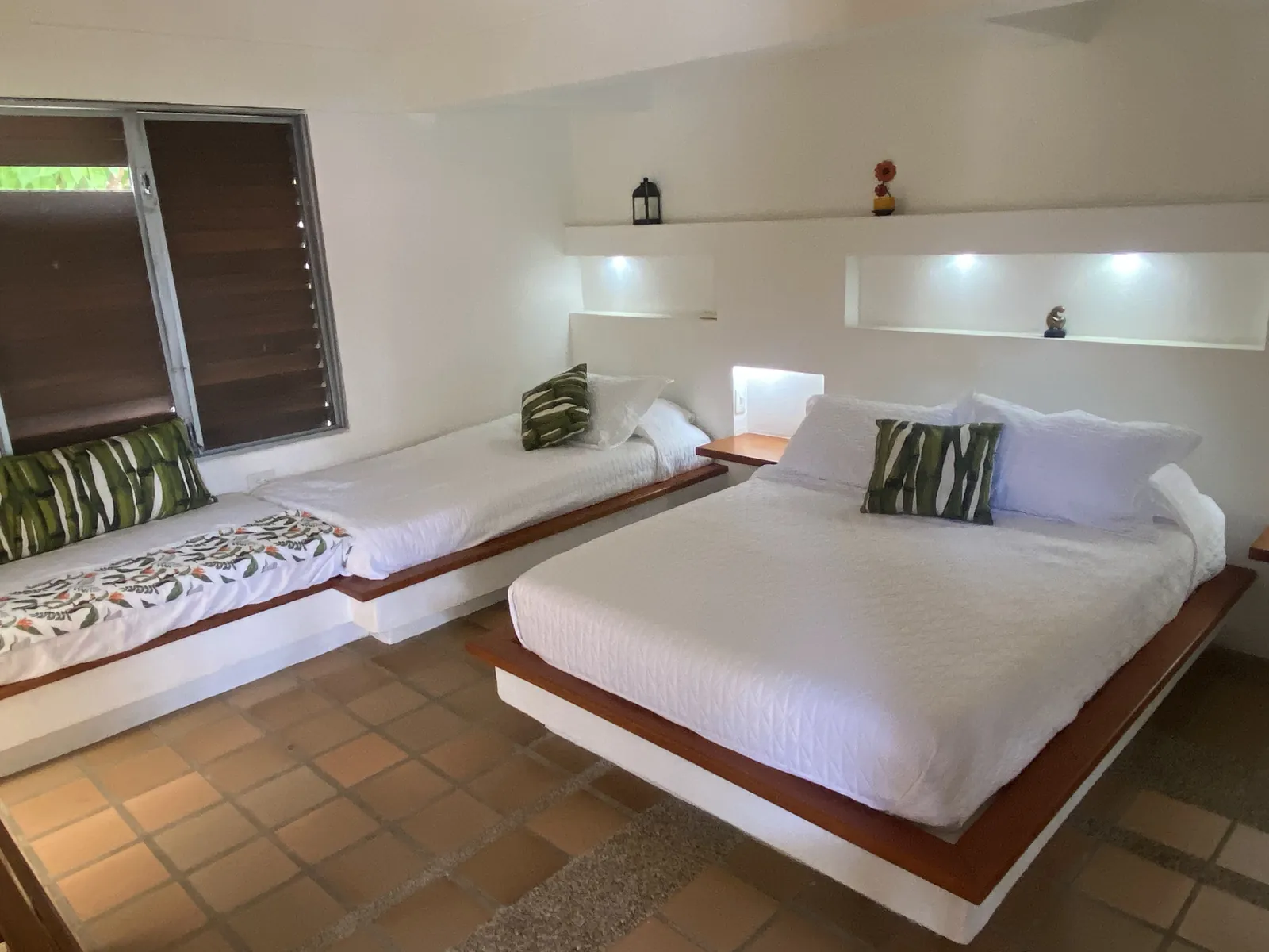 Habitación con cama doble y diván, con luces encendidas